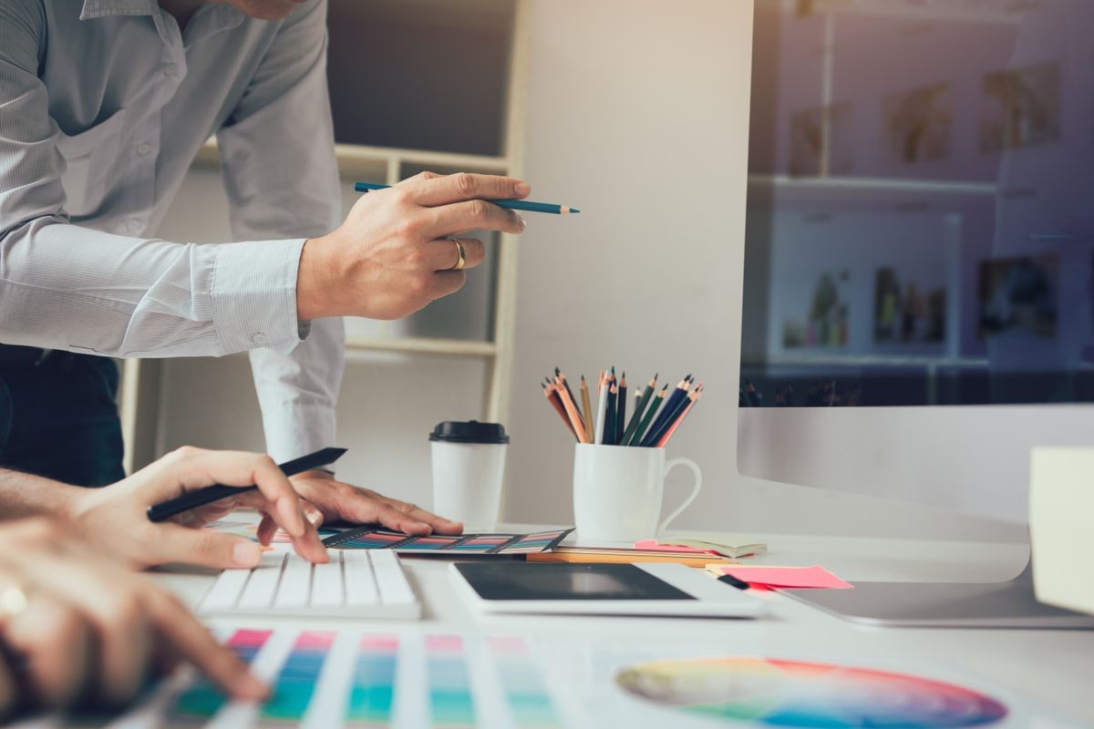 Designer holding pencil and pointing computer screen with working together.